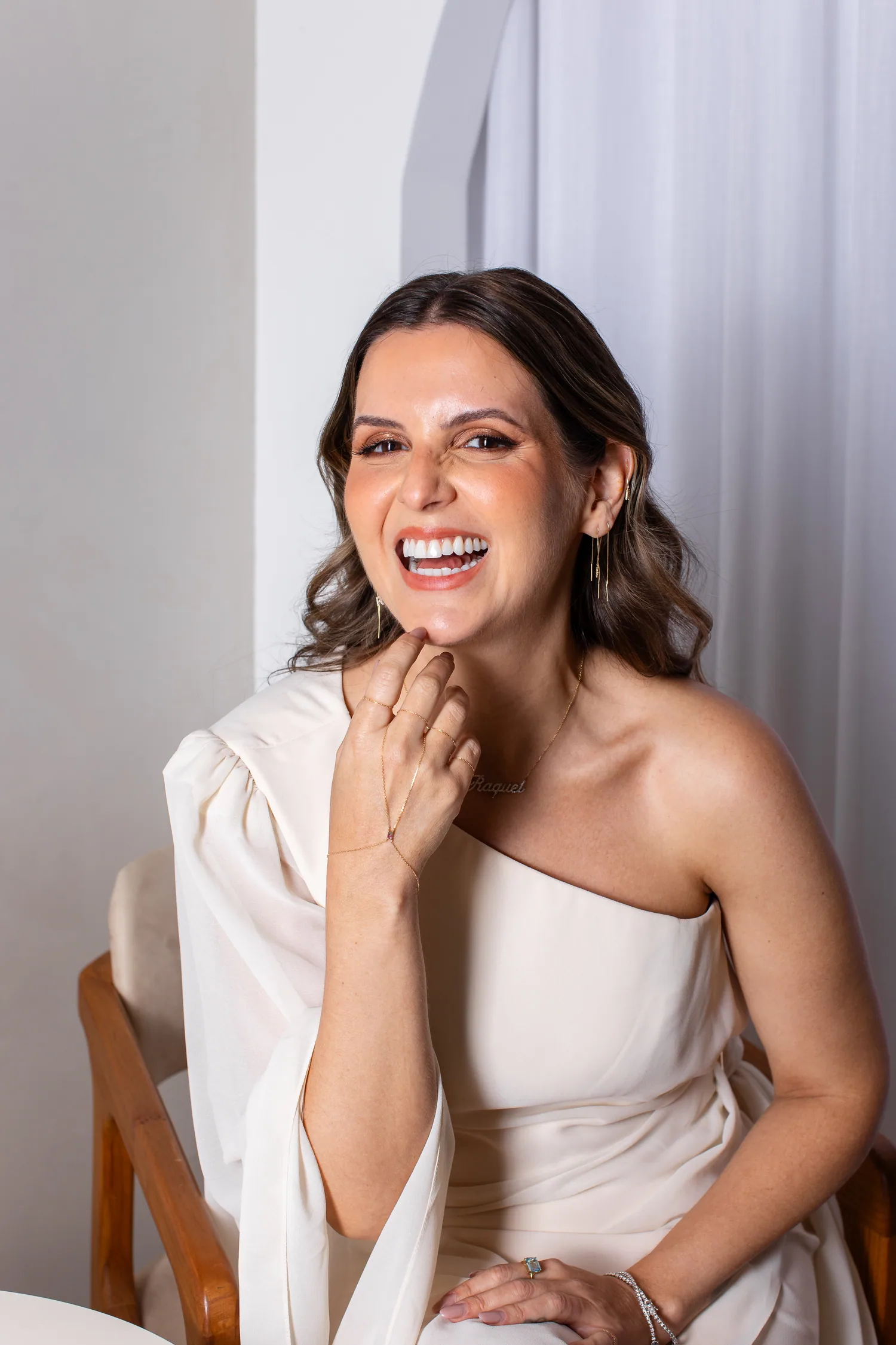 Raquel Braga sorrindo, com o colar com o próprio nome